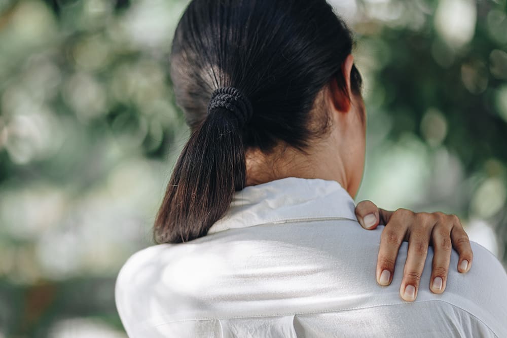 a woman holding her shoulder