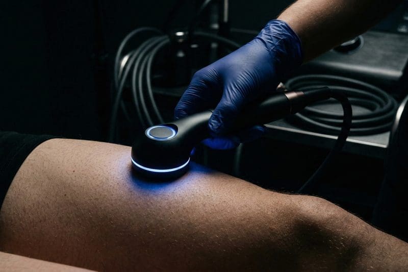 A person performing PEMF therapy on a patient.